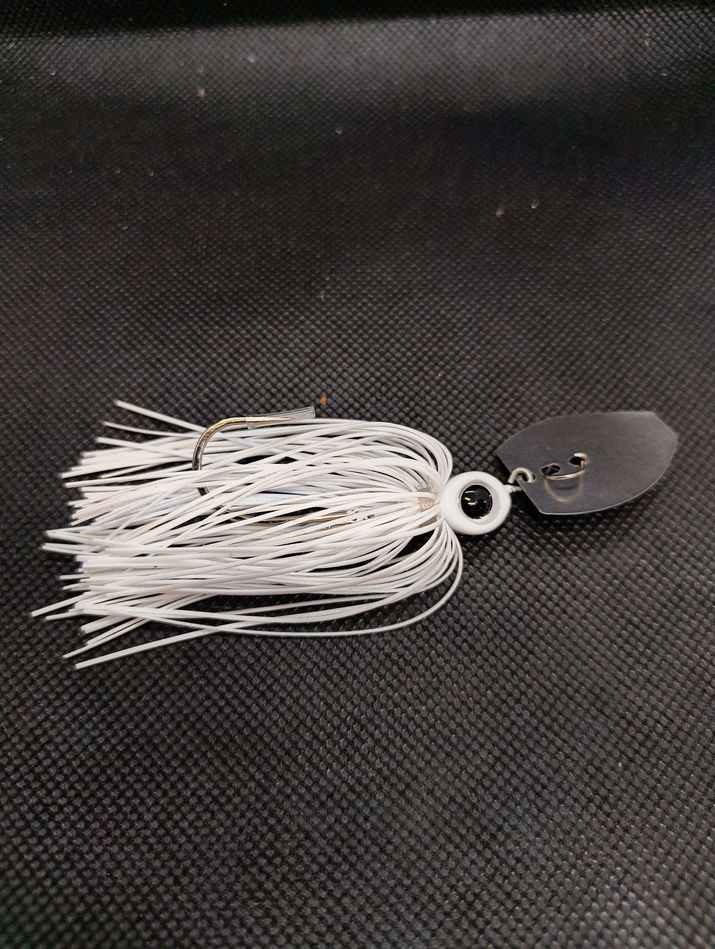 Limestone Softbaits ShadShaker chatter bait with a sleek black and blue jig head and a flexible plastic shad body for fishing.