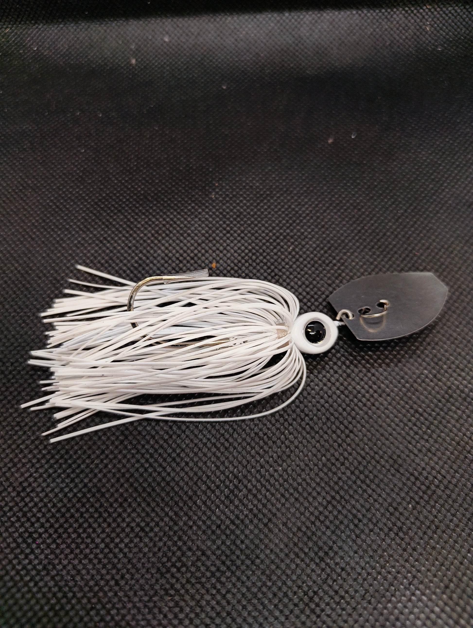 Limestone Softbaits ShadShaker chatter bait with a sleek black and blue jig head and a flexible plastic shad body for fishing.
