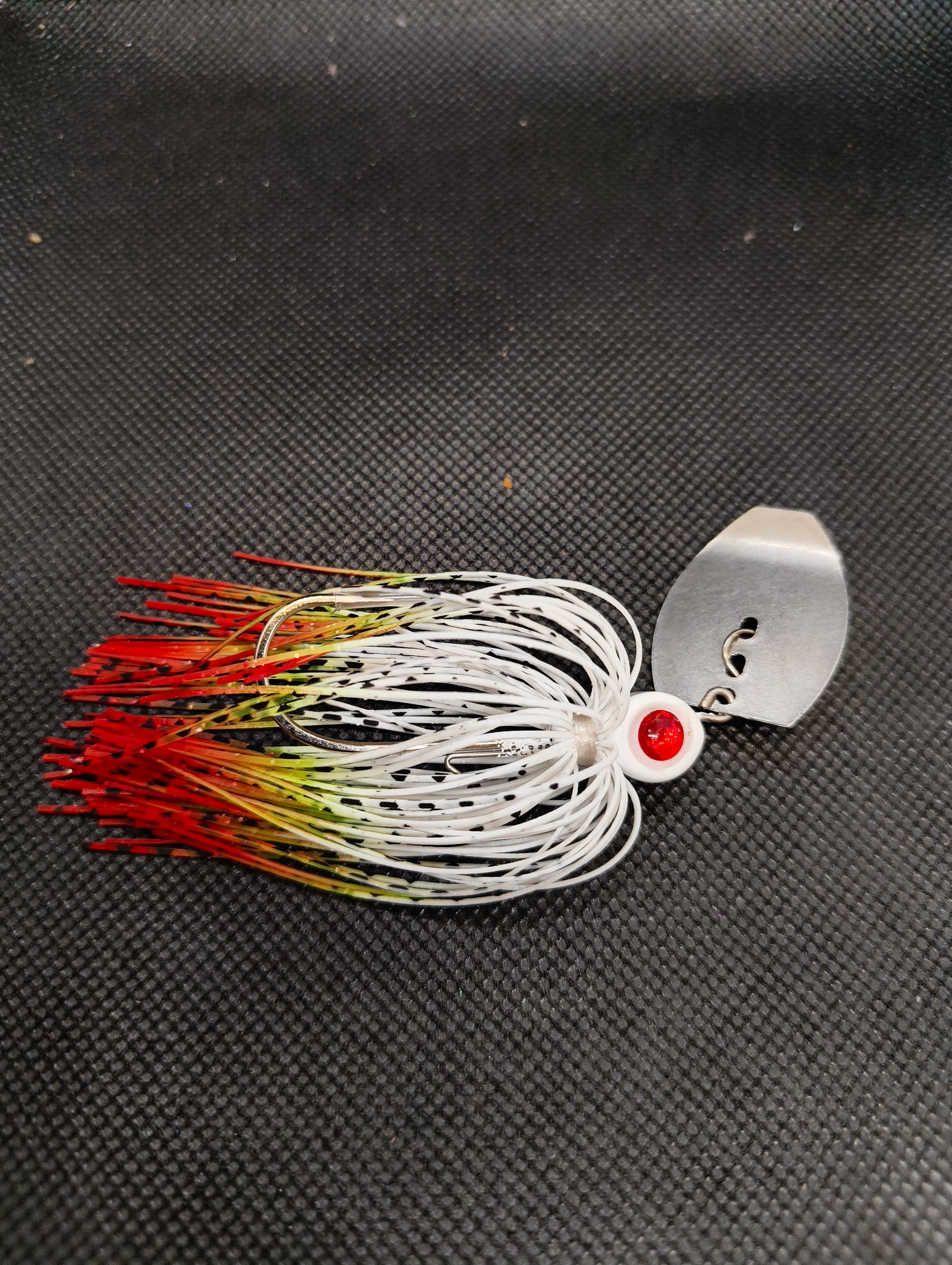 Limestone Softbaits ShadShaker chatterbait with a sleek black and blue soft plastic lure attached to a silver fishing jig head.